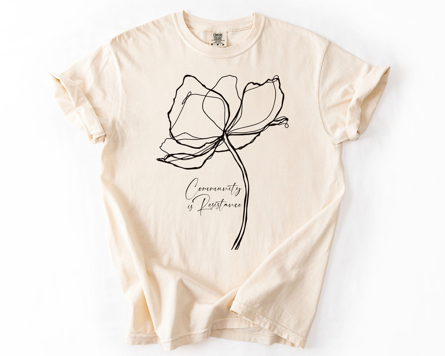 Ivory t-shirt with Community Is Resistance botanical graphic – human rights shirt