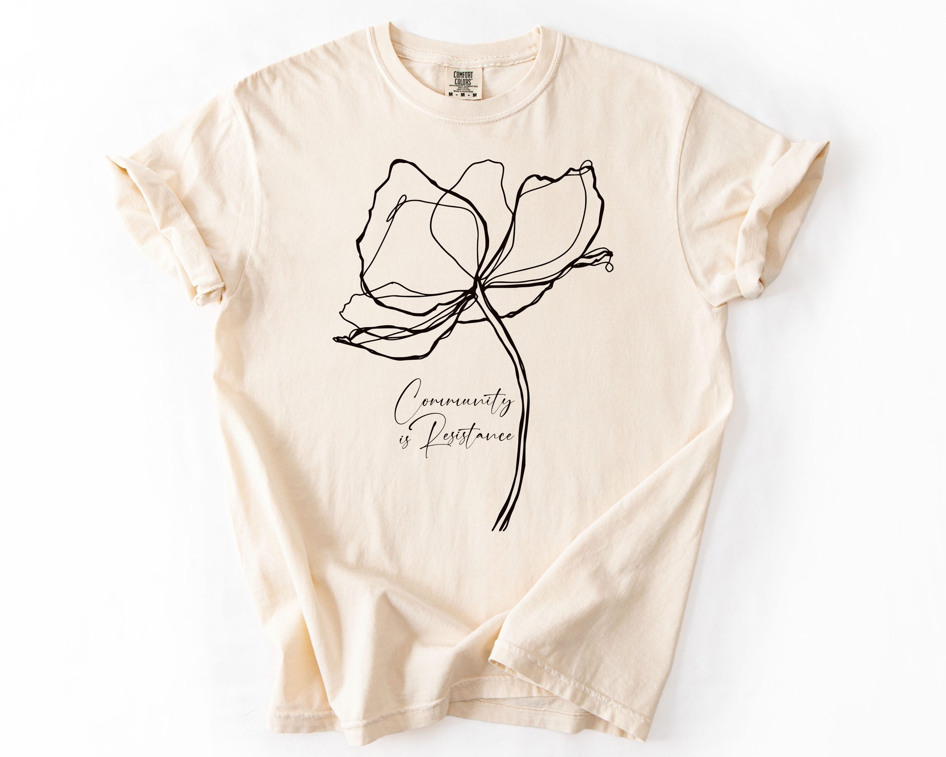 Ivory t-shirt with Community Is Resistance botanical graphic – human rights shirt