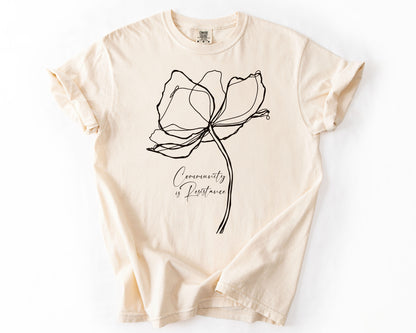 Ivory t-shirt with Community Is Resistance botanical graphic – human rights shirt